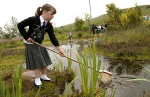 Students in Scotland engage in hands-on learning at a wetland. Photo courtesy of ExxonMobil.